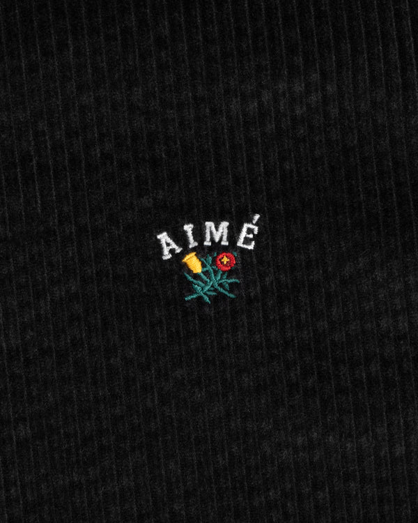 Black corduroy Corduroy Leon Overshirt fabric embroidered with the word AIMÉ above a flower.
