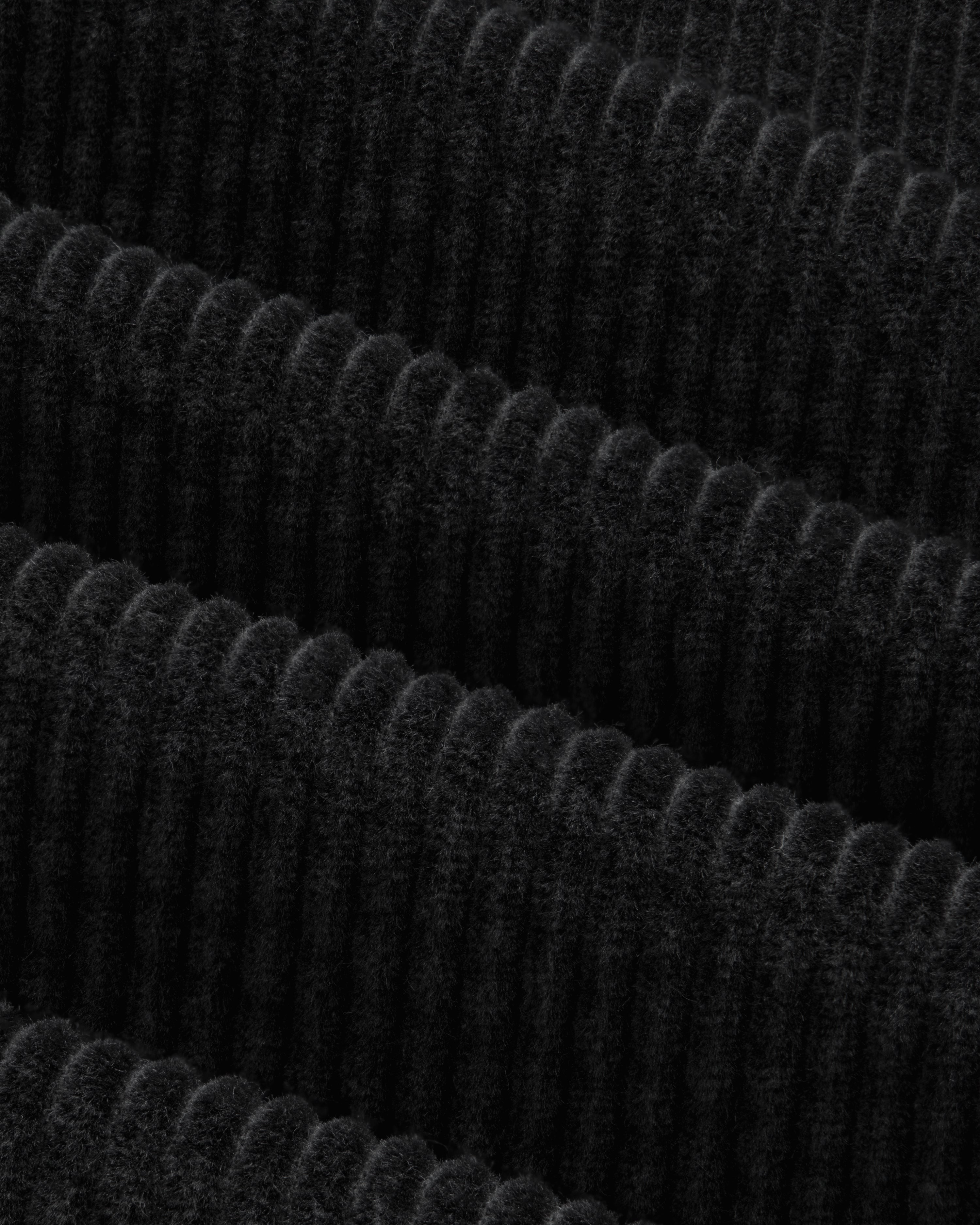 Close-up of the black Corduroy Leon Overshirt featuring fabric with wide, vertical wales.
