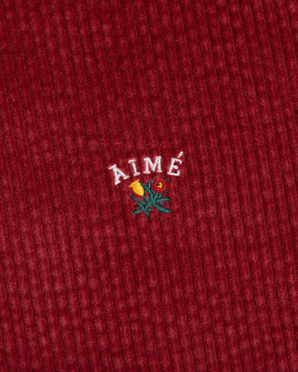 Corduroy Leon Overshirt in red corduroy with an embroidered floral graphic and the word AIME above it.