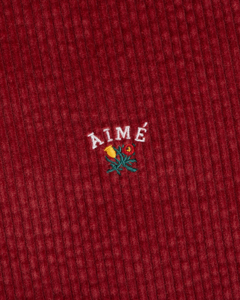 Corduroy Leon Overshirt in red corduroy with an embroidered floral graphic and the word AIME above it.