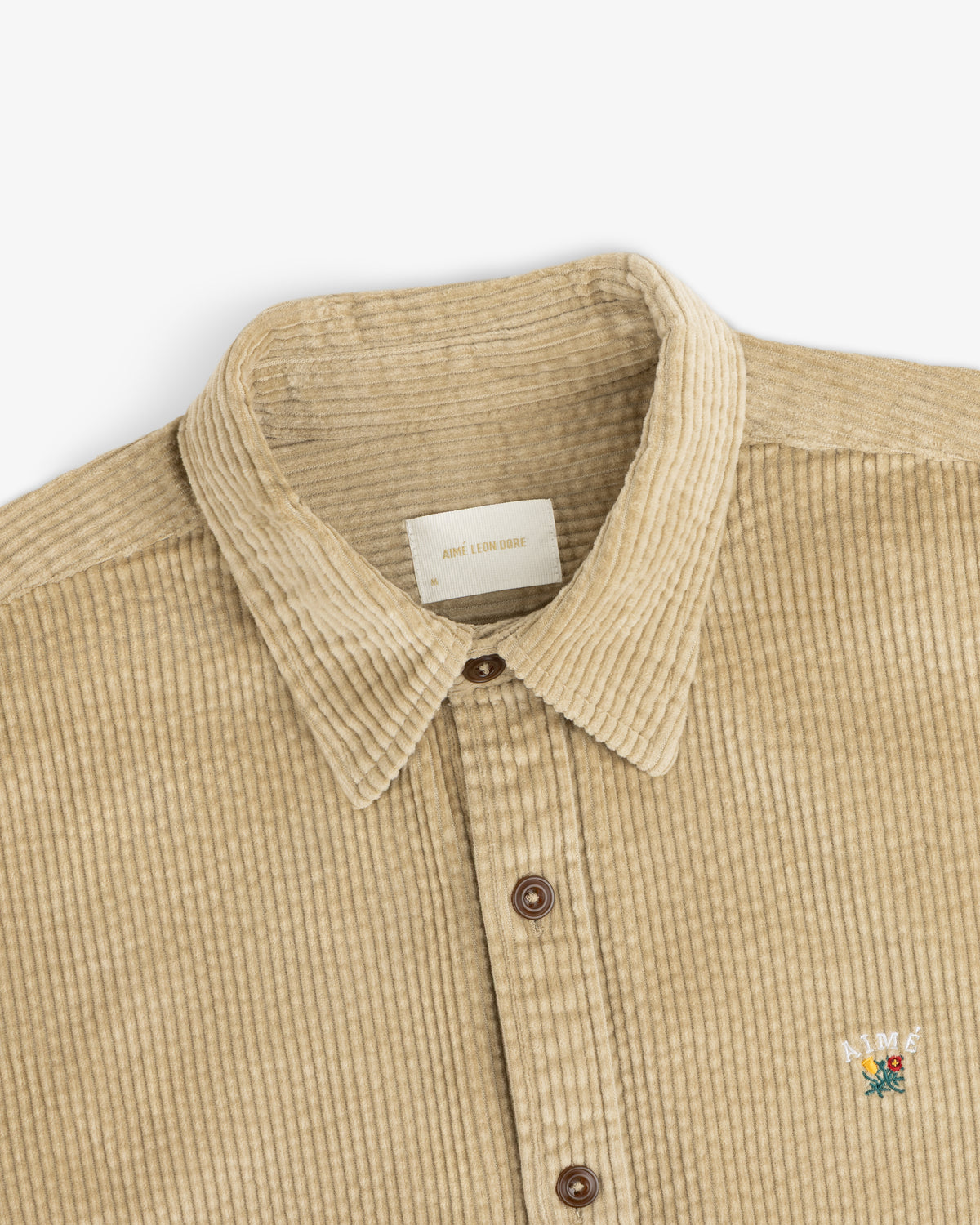 Tan Corduroy Leon Overshirt with a button-down front and a small floral logo on the chest.
