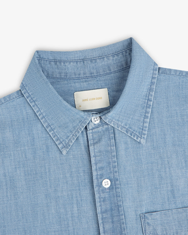 Bayard Chambray Shirt: light blue denim, pointed collar, white buttons, chest pocket; shown on white background.