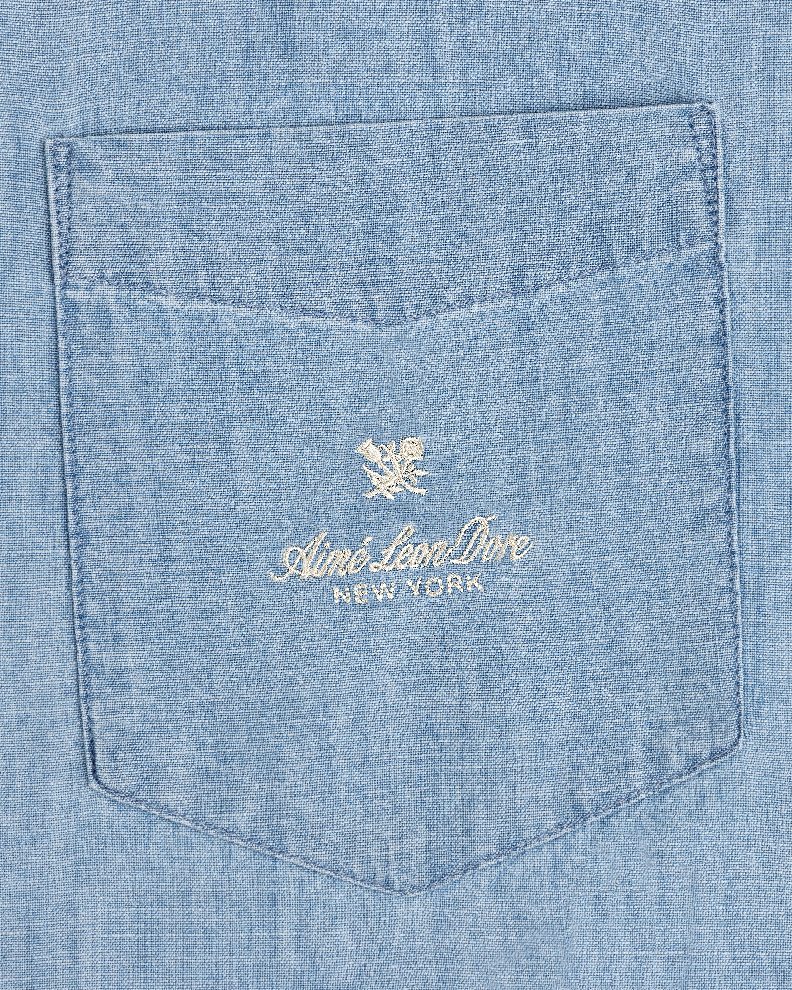 Bayard Chambray Shirt: Light blue pocket with white “Aimé Leon Dore NEW YORK” embroidery and a flower logo above.