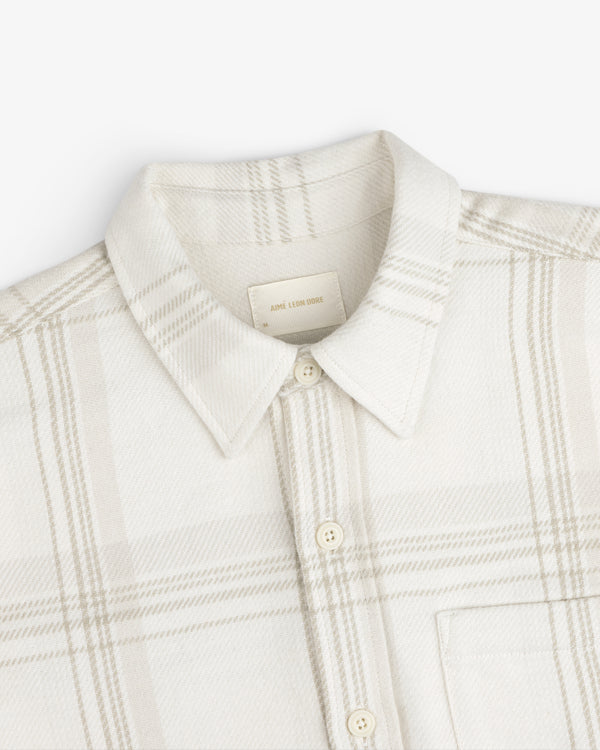 Yarn Dyed Plaid Overshirt: light-colored long-sleeve button-down with a subtle plaid pattern and a pointed collar.