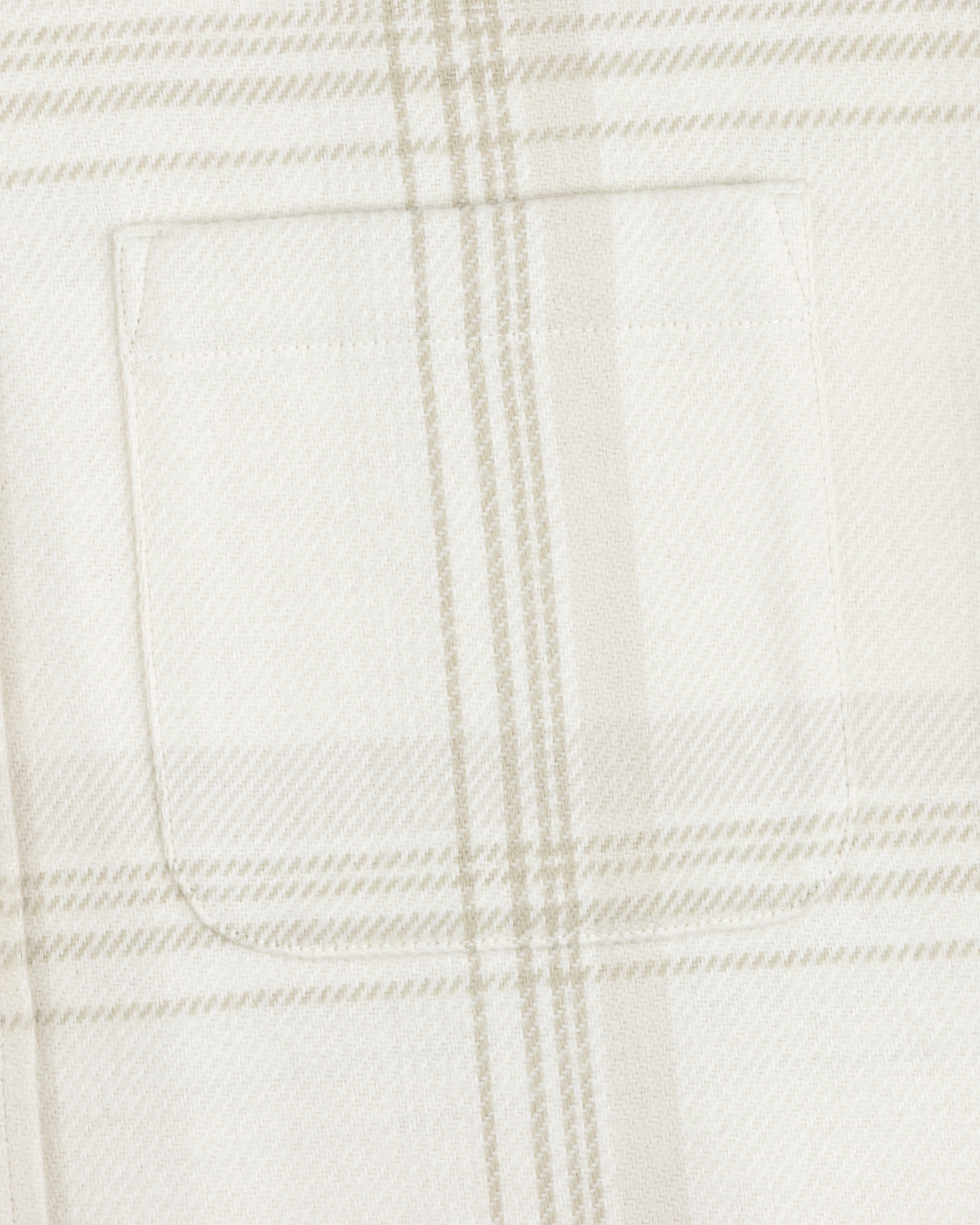 Close-up of a chest pocket on the Yarn Dyed Plaid Overshirt in white and beige.