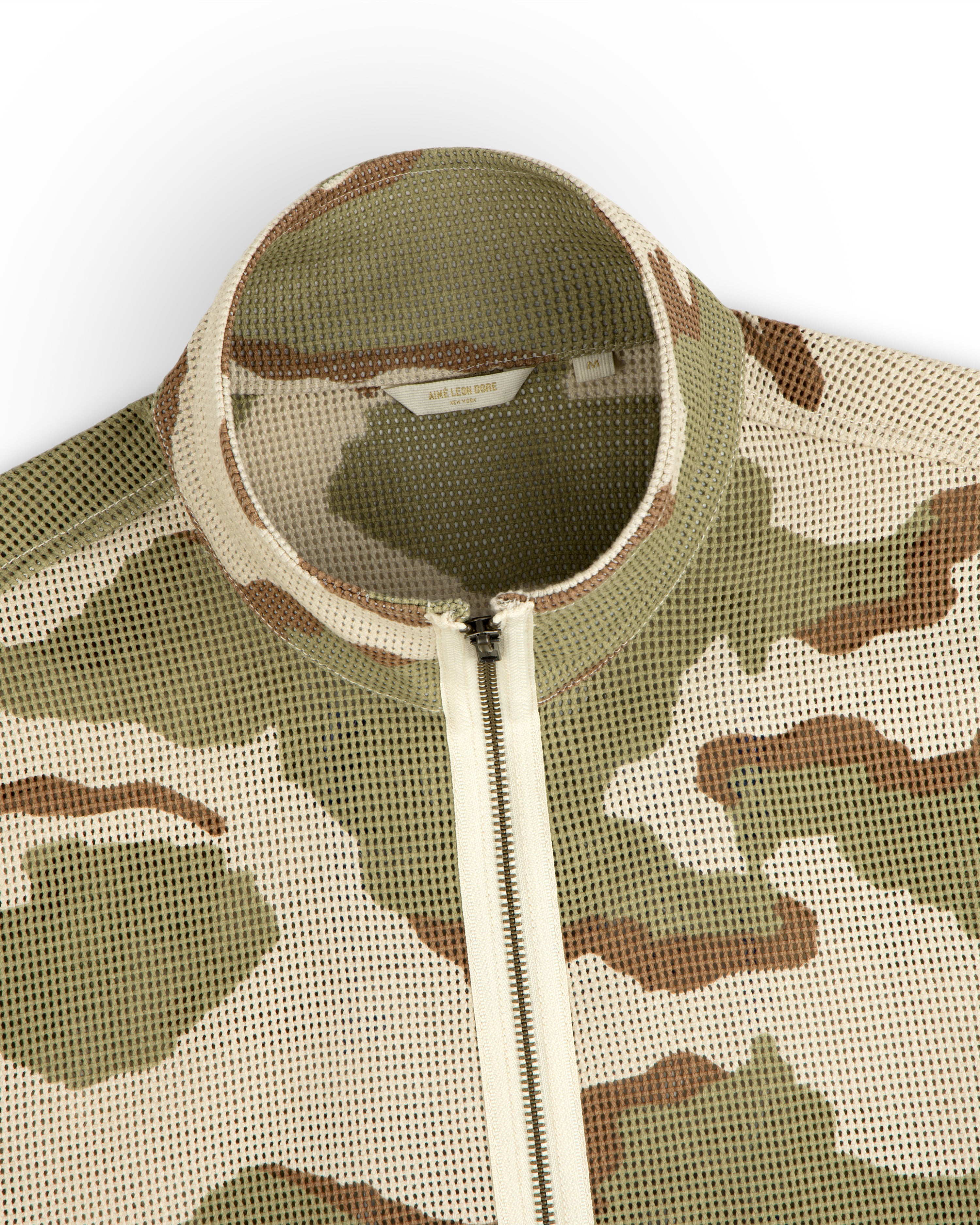 Camo Mesh Zip Overshirt in camo print mesh with a mock neck, front zipper, and internal brand label.