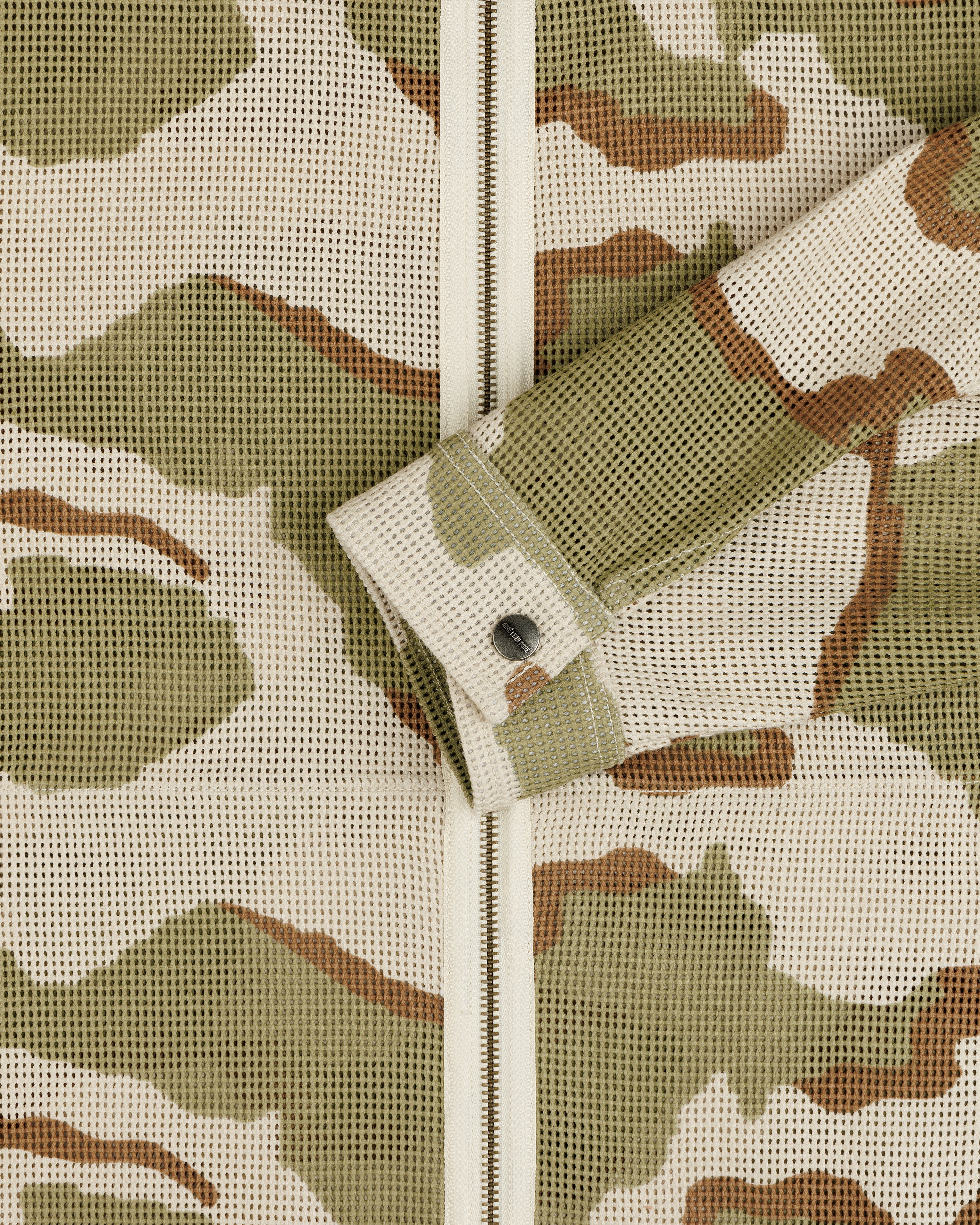 Camo Mesh Zip Overshirt in a tan, olive, and brown camouflage mesh fabric with a buttoned sleeve cuff.