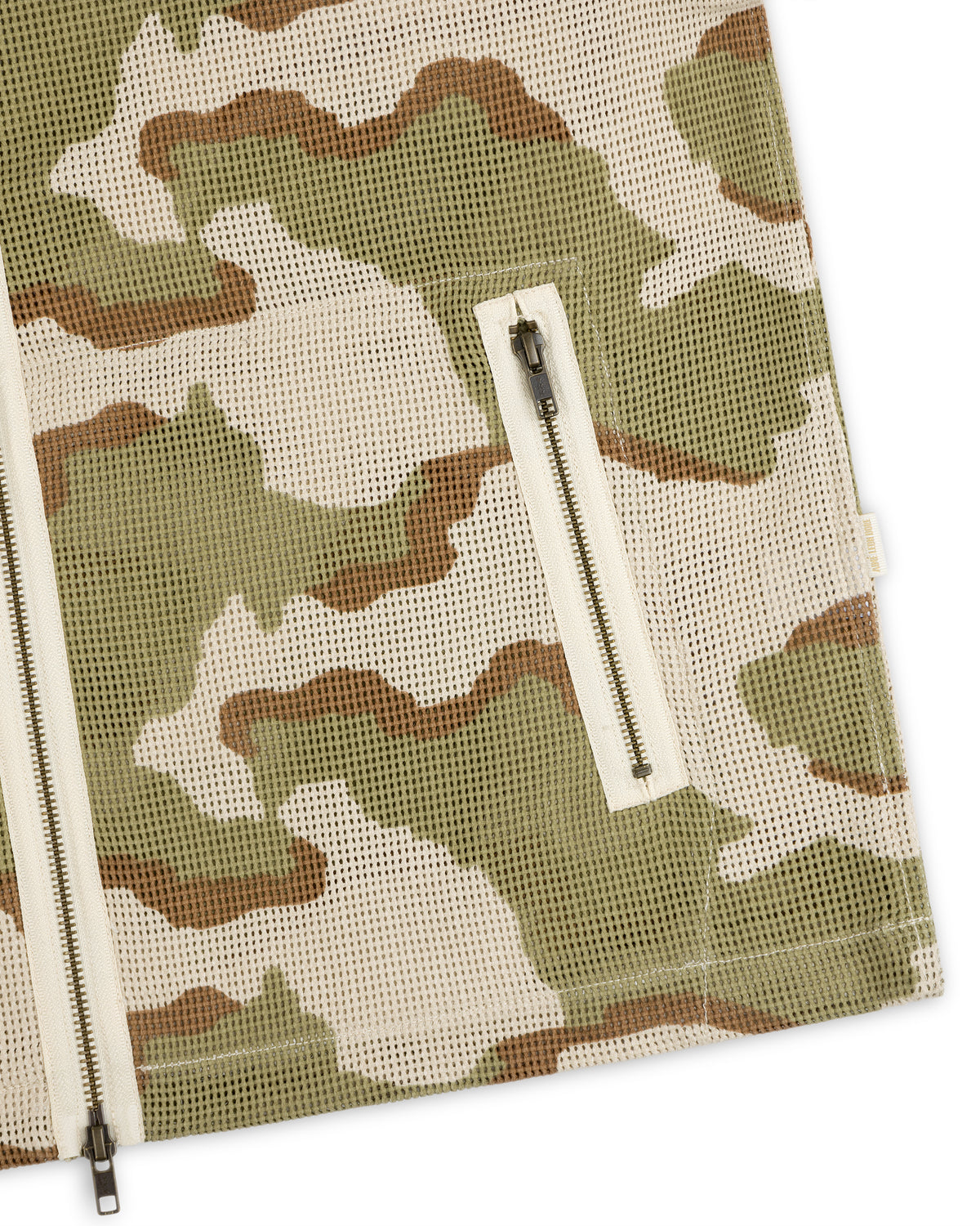 Close-up of a Camo Mesh Zip Overshirt in green, brown, and beige, featuring a zippered pocket and front zipper.