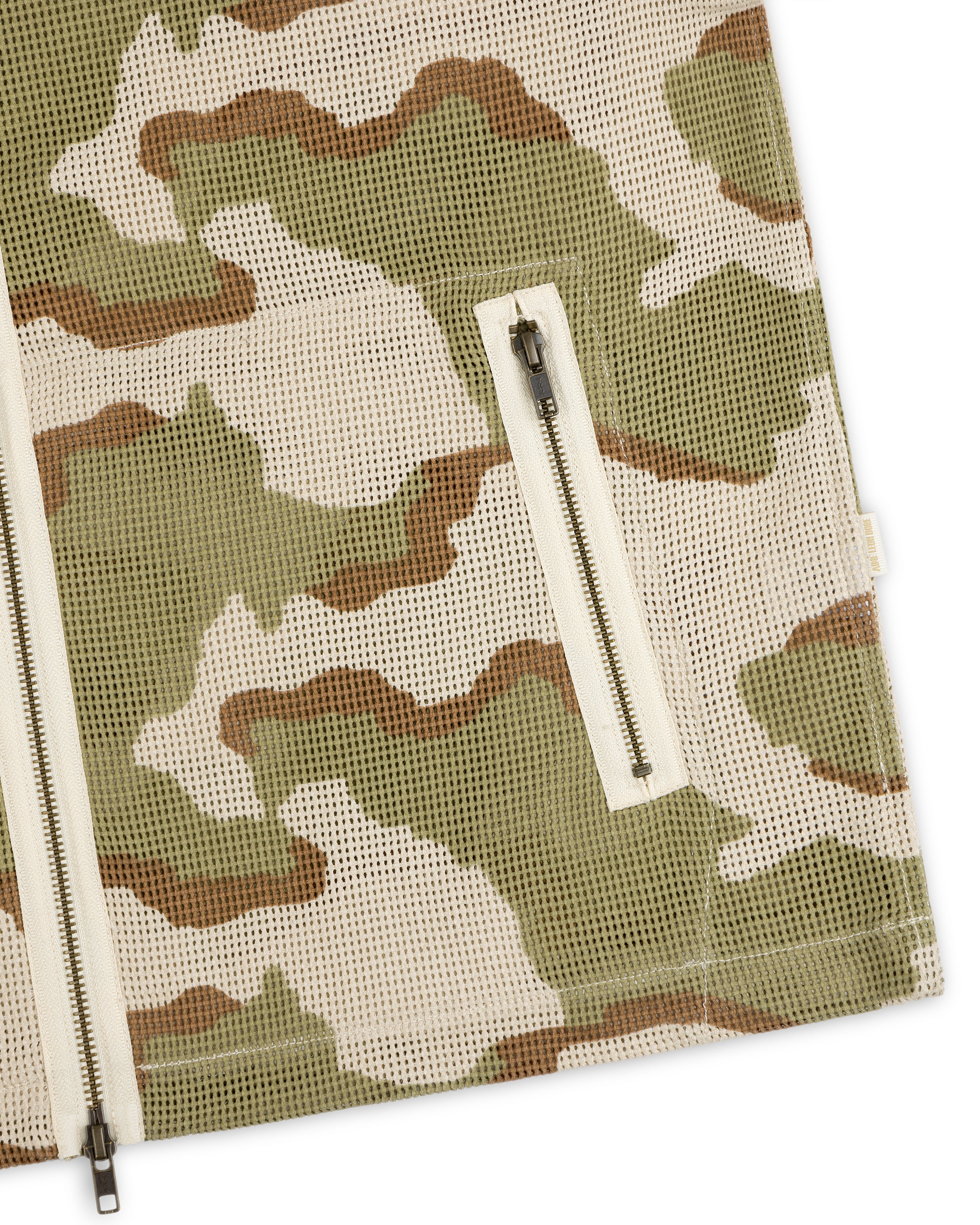 Close-up of a Camo Mesh Zip Overshirt in green, brown, and beige, featuring a zippered pocket and front zipper.