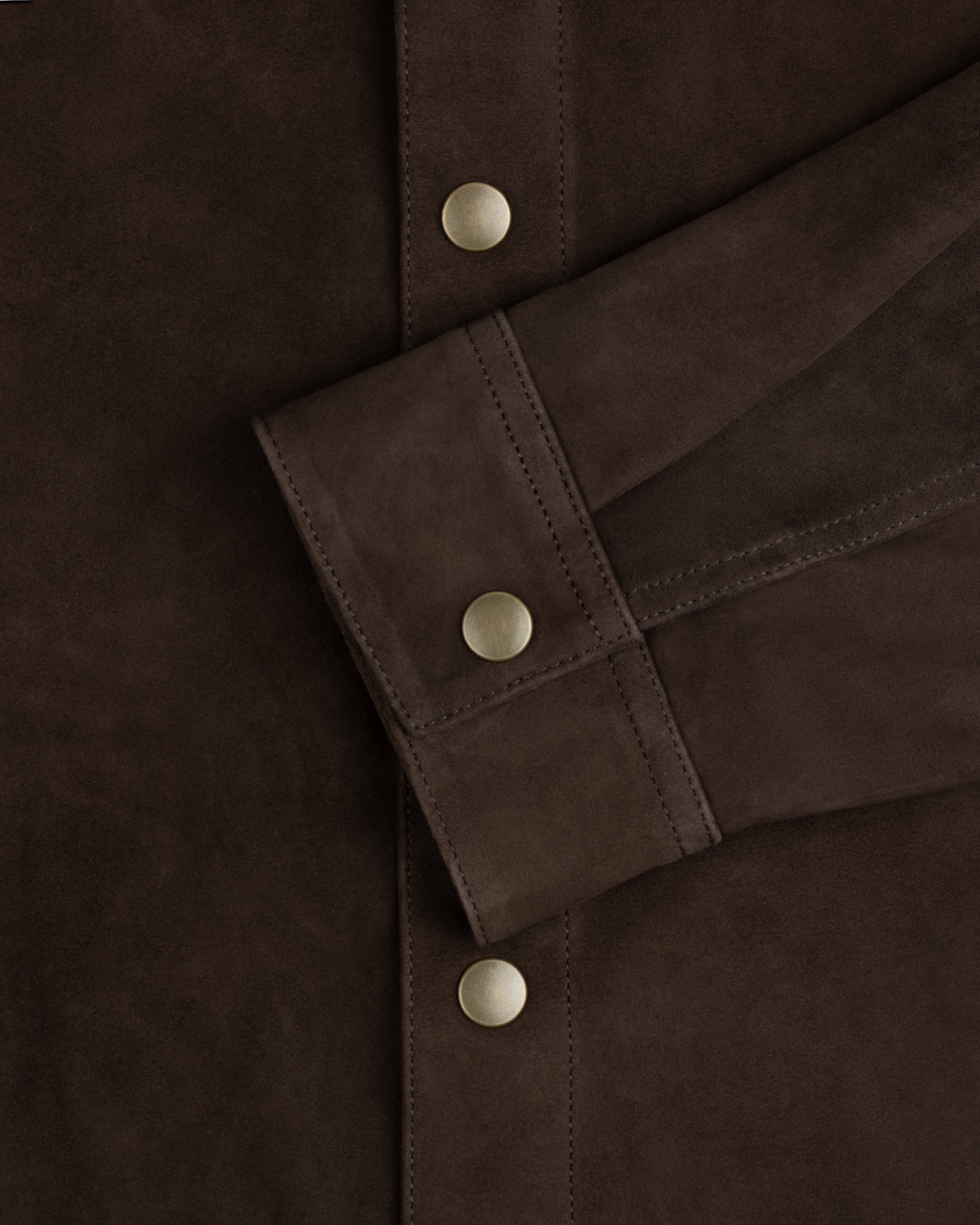 Dark brown suede cuff of the Suede Overshirt with a matte gold snap button.