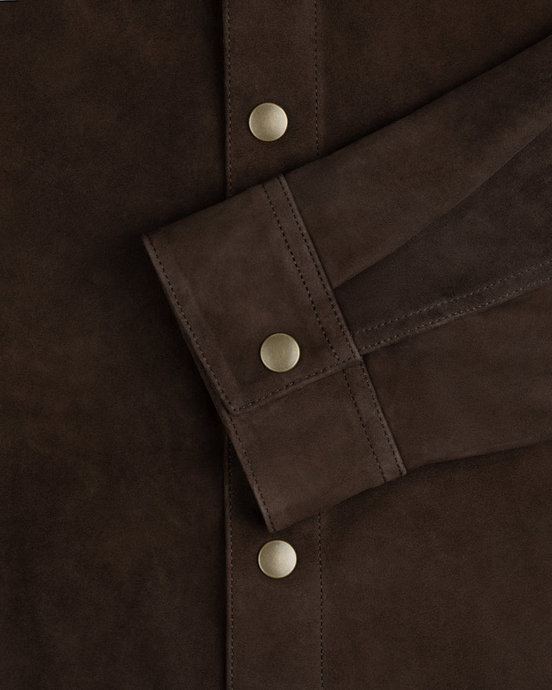 Dark brown suede cuff of the Suede Overshirt with a matte gold snap button.