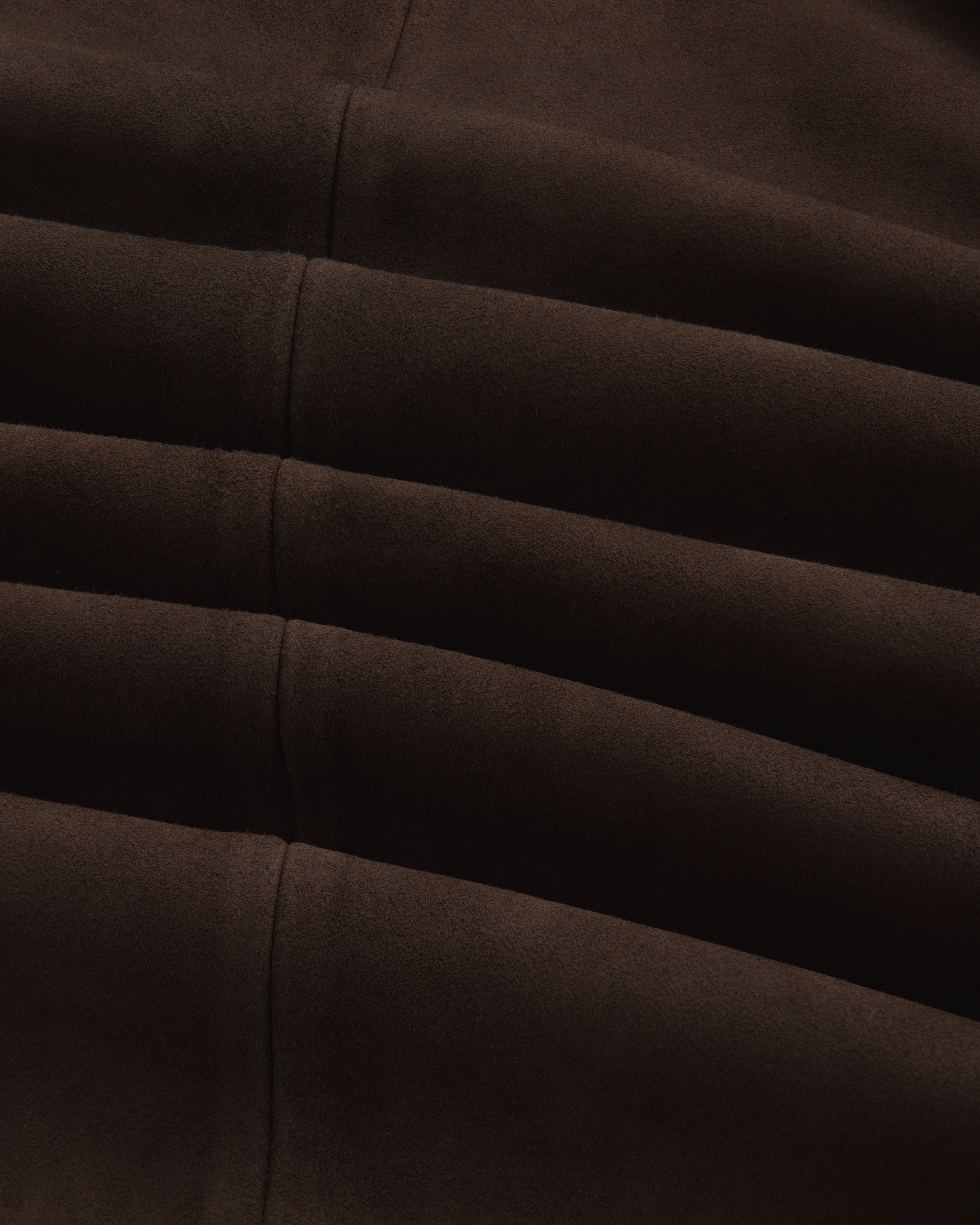 Close-up of the dark brown Suede Overshirt showing its fabric texture, seams, and folds.