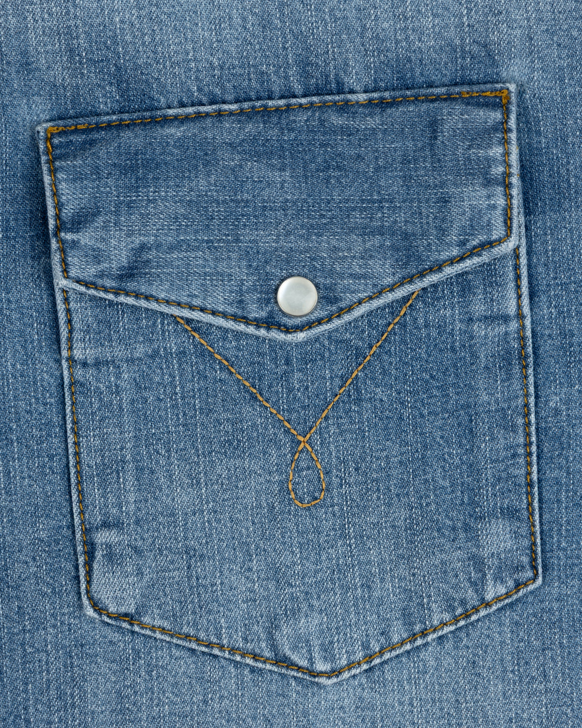 A Denim Western Shirt pocket with a pointed flap, silver snap button, and decorative gold stitching.