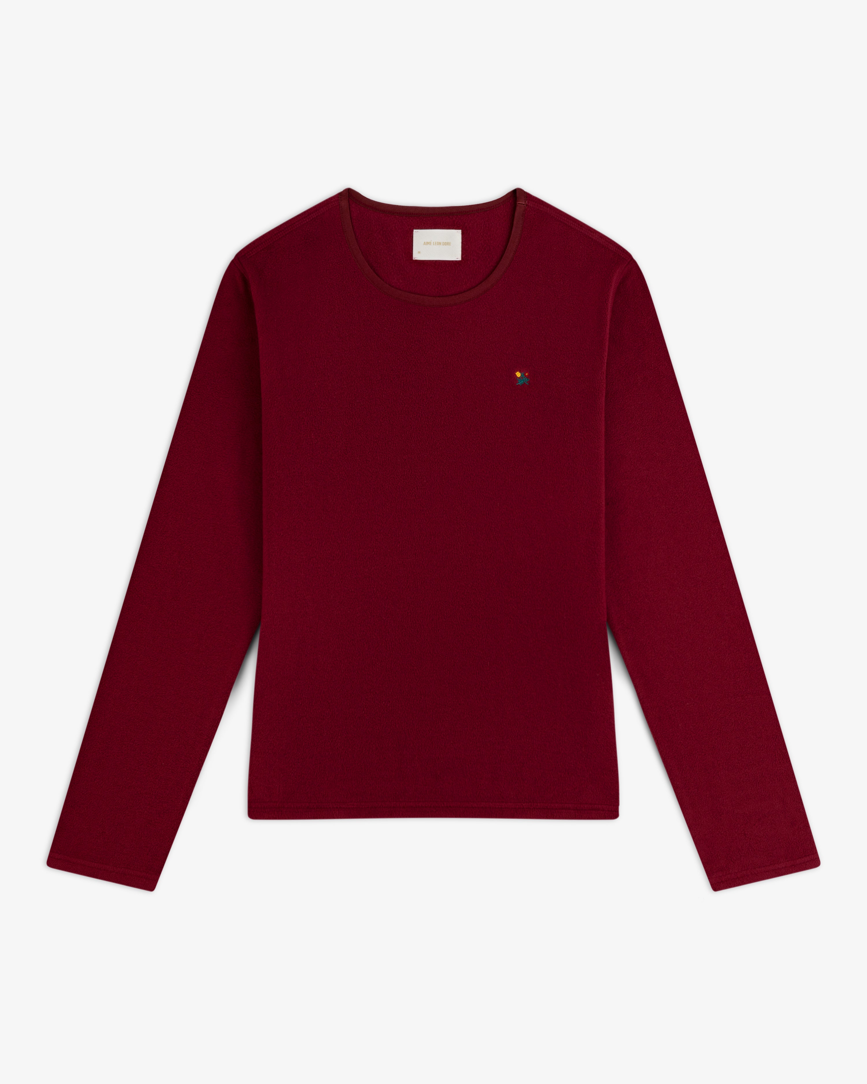 Deep red Crest Long-Sleeve Fleece Tee with a small multicolored floral embroidery on the chest.