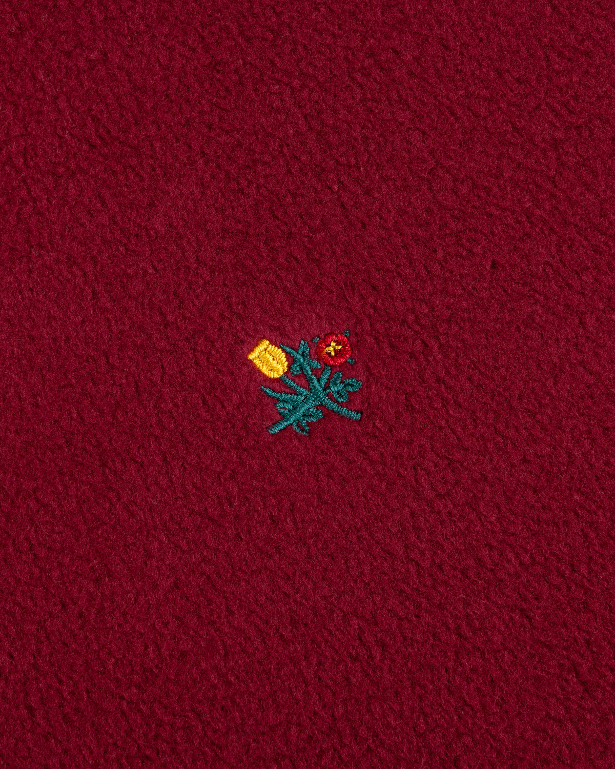 Maroon Crest Long-Sleeve Fleece Tee with an embroidered yellow tulip and a red flower with green stems.