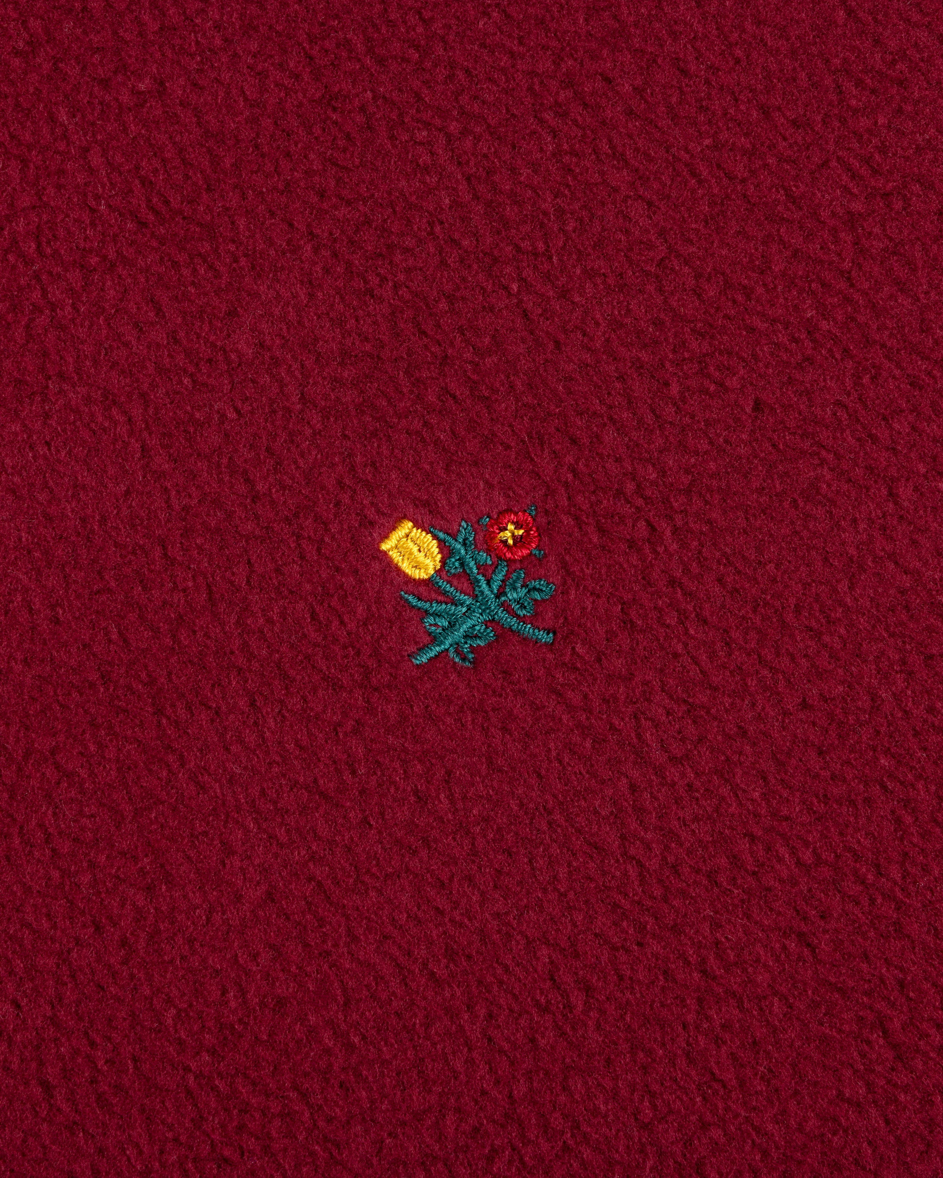 Maroon Crest Long-Sleeve Fleece Tee with an embroidered yellow tulip and a red flower with green stems.