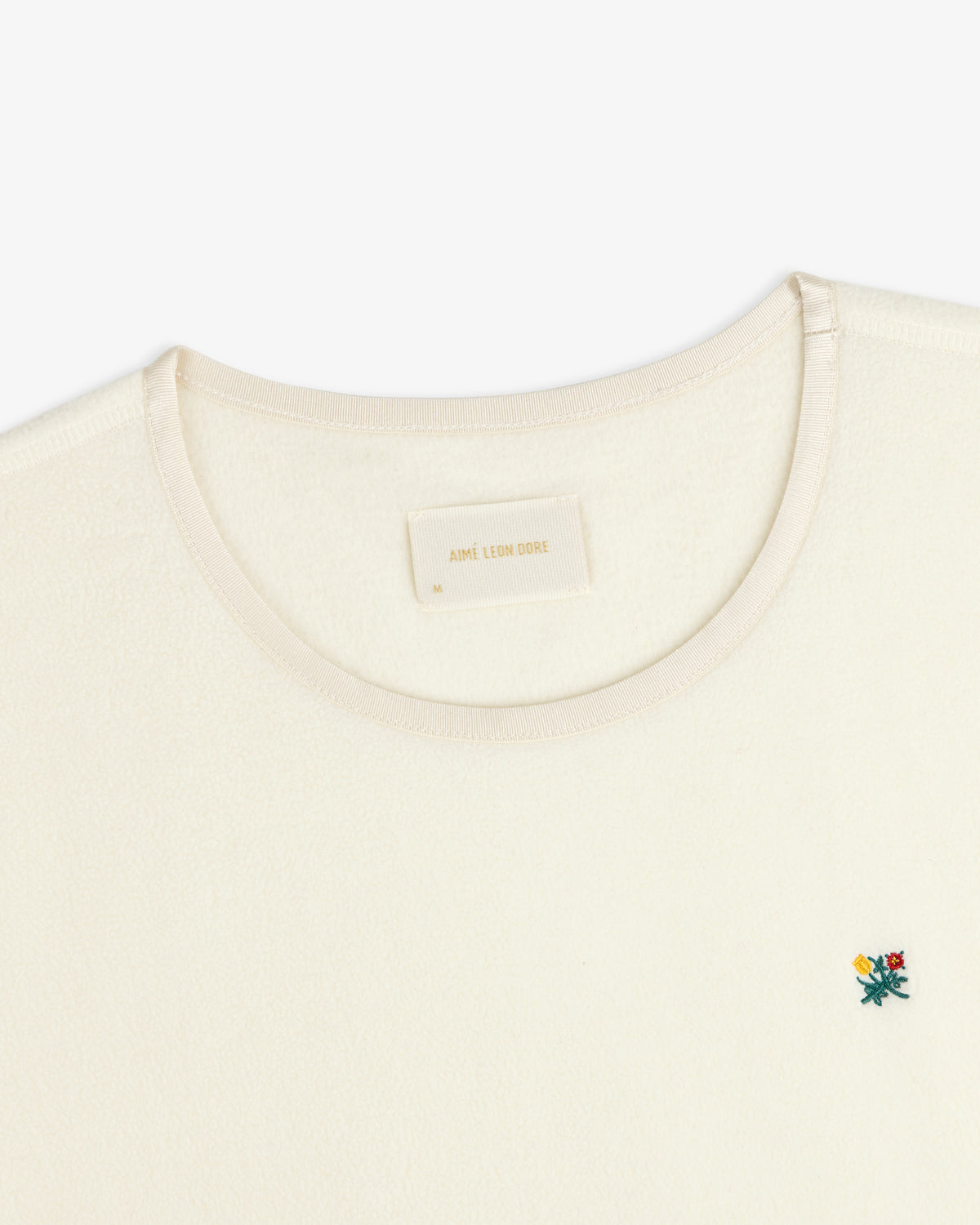 Crest Long-Sleeve Fleece Tee in cream with a small floral embroidery and an interior neck label.
