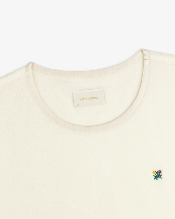 Crest Long-Sleeve Fleece Tee in cream with a small floral embroidery and an interior neck label.