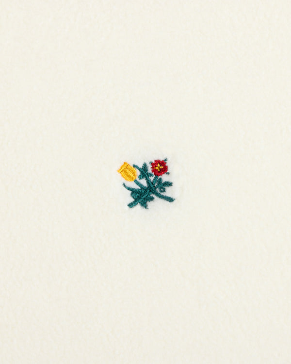 Crest Long-Sleeve Fleece Tee in cream-colored fleece with a small red, yellow, and green embroidered floral design.