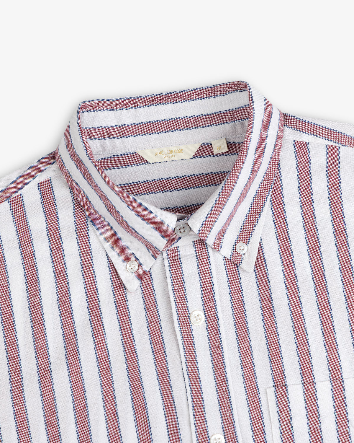 Striped Crest Oxford Shirt: white with red and blue vertical stripes, front pocket, classic button-down style.