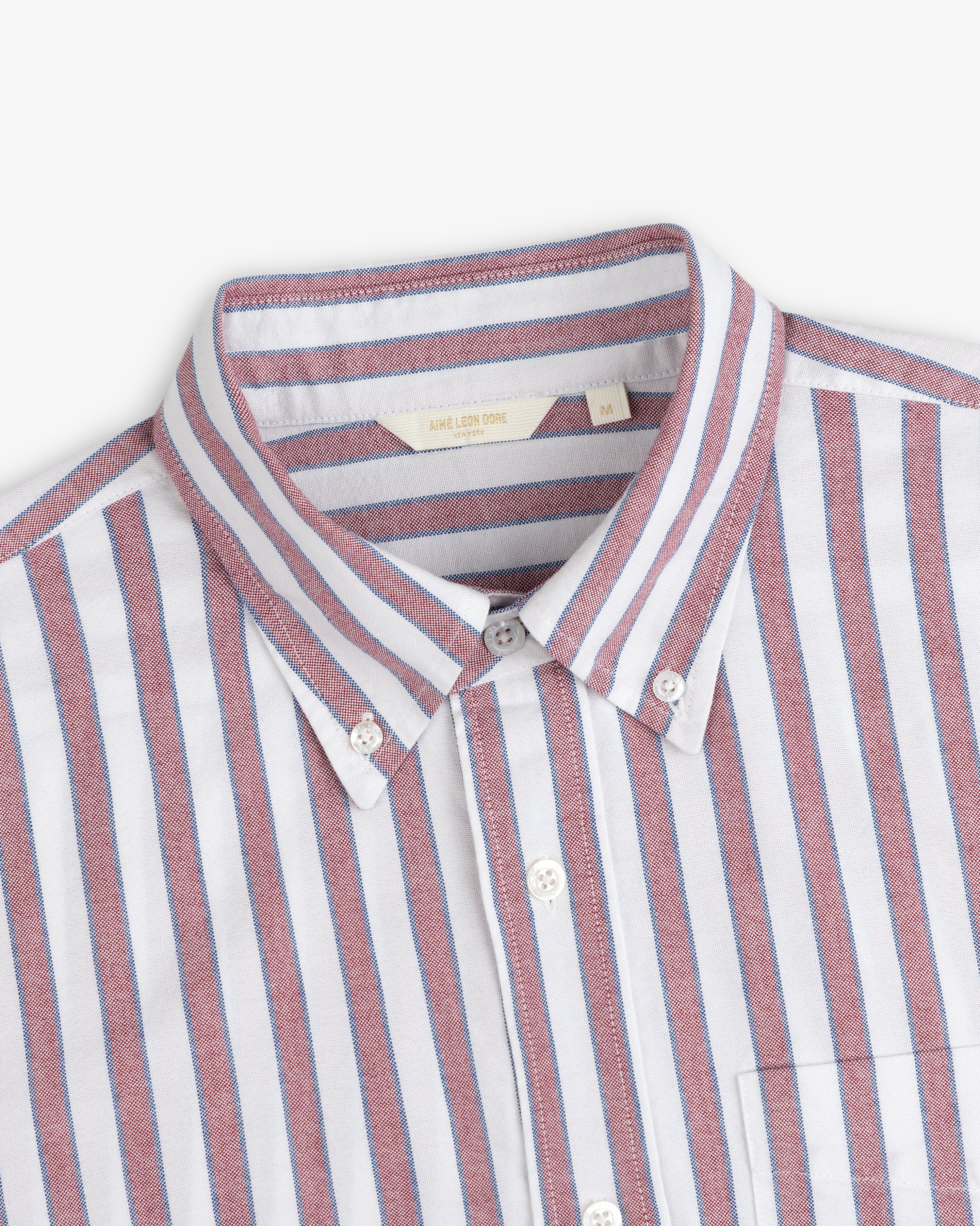 Striped Crest Oxford Shirt: white with red and blue vertical stripes, front pocket, classic button-down style.