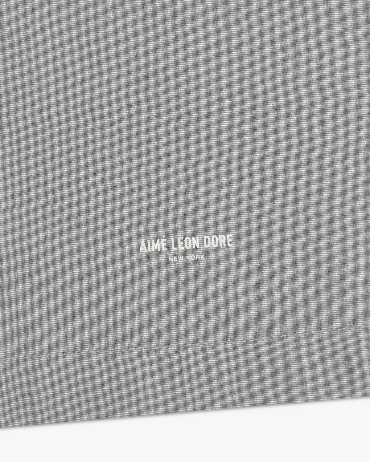 Gray Poplin Casual Shirt with small white Aimé Leon Dore New York text near the stitched hem.