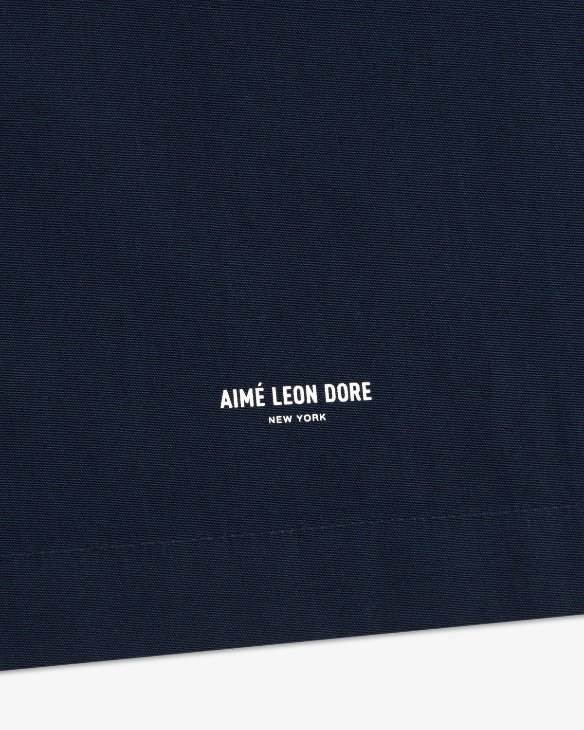 Close-up of navy Poplin Casual Shirt with AIMÉ LEON DORE NEW YORK in small white print near the bottom.