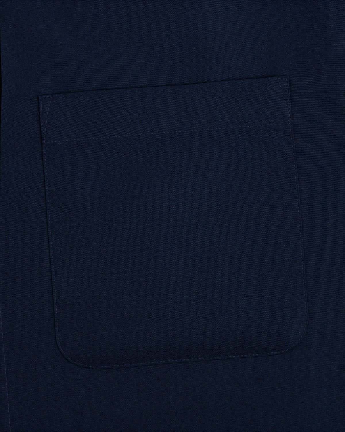 Close-up of a navy Poplin Casual Shirt fabric featuring a stitched square pocket.