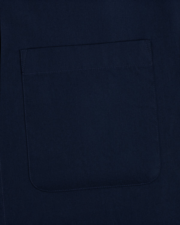 Close-up of a navy Poplin Casual Shirt fabric featuring a stitched square pocket.