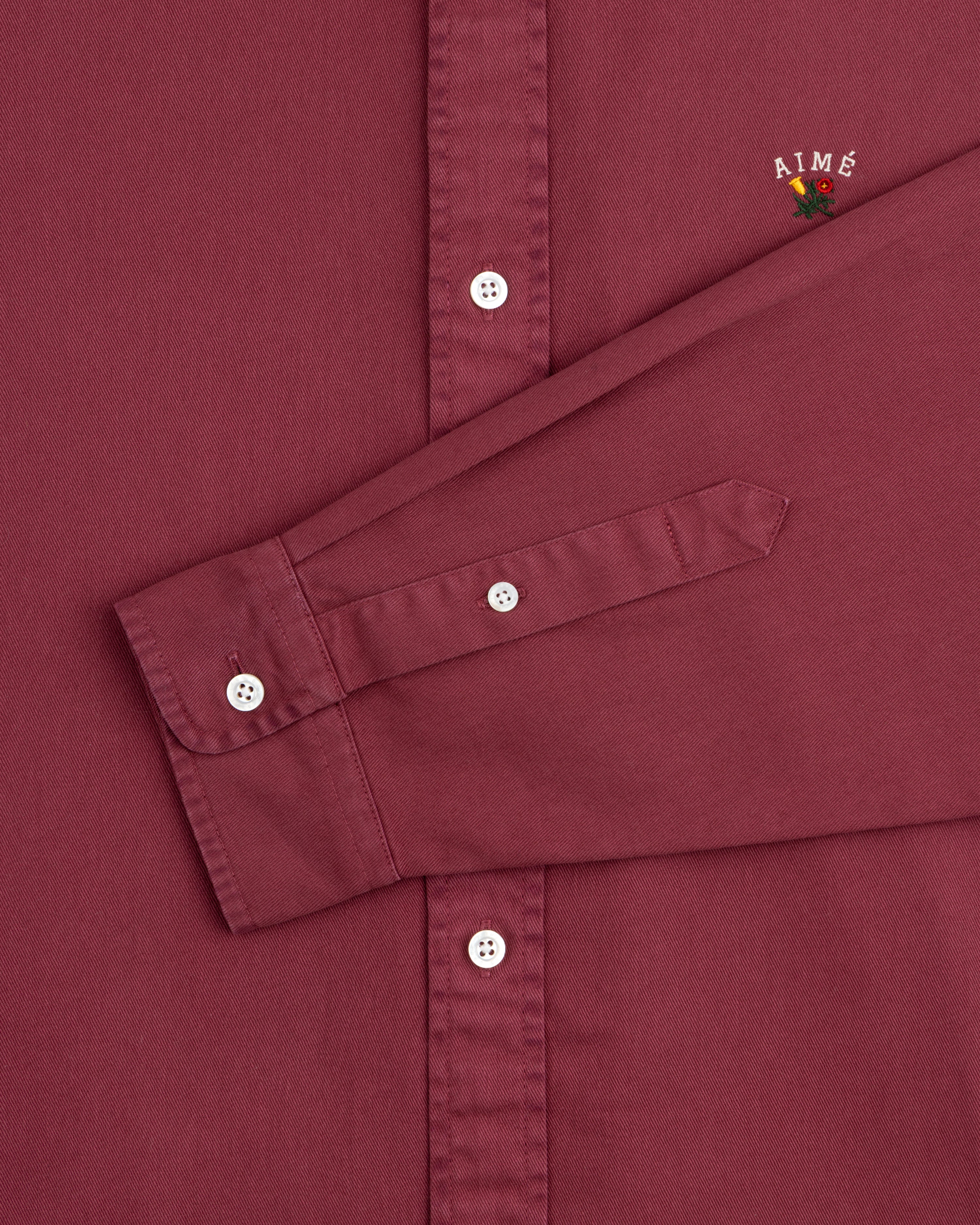 Maroon Garment Dyed Leon Overshirt with long sleeves, AIMÉ and small flower embroidery near the shoulder.