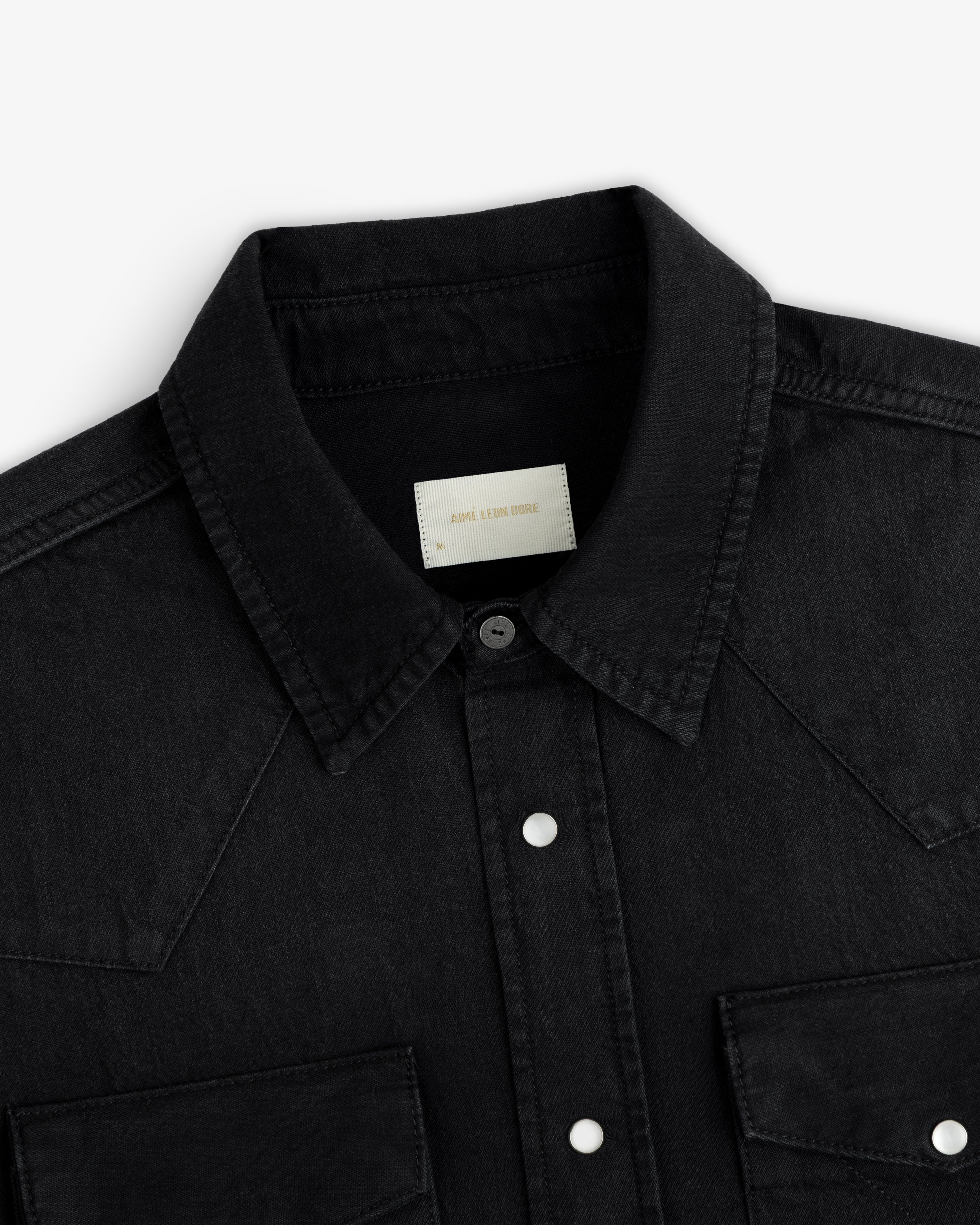 Close-up of a black Denim Western Shirt with a collar, snap buttons, and chest pockets.