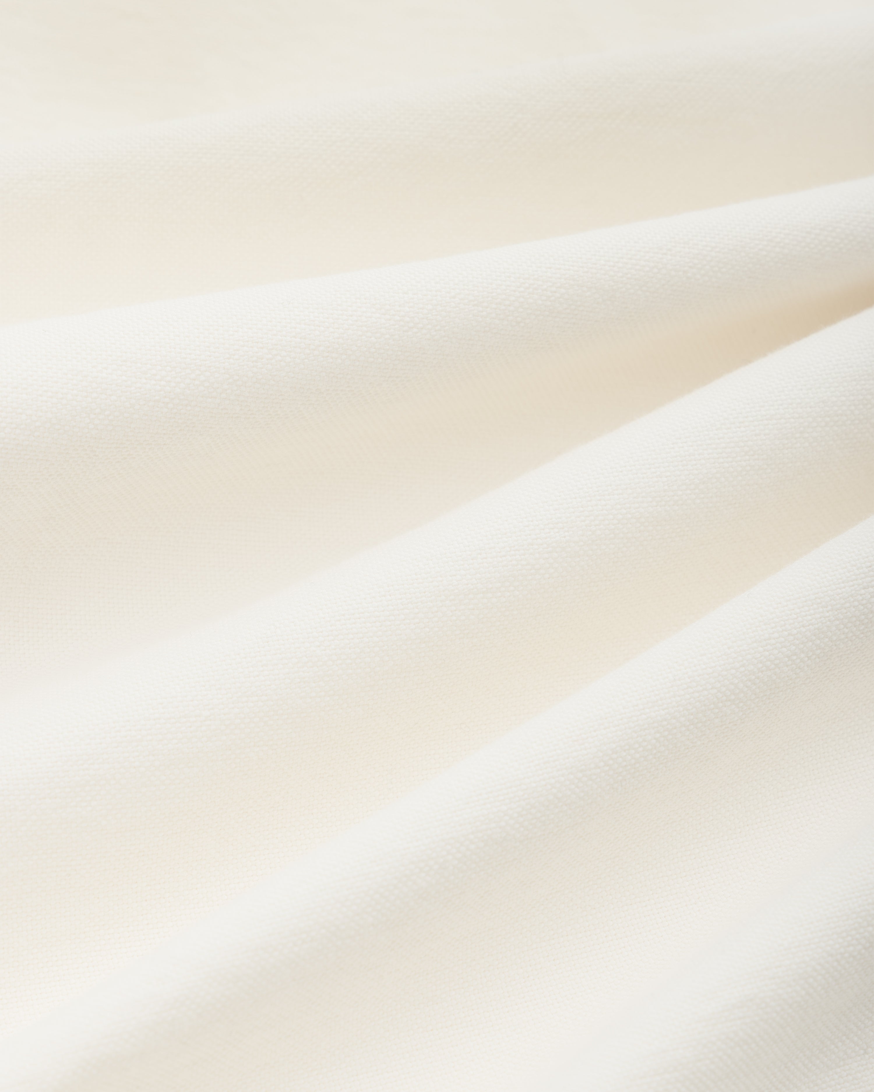 Off-white cotton fabric of the ALD / Olympiacos F.C. Logo Oxford Shirt with soft, diagonal folds.
