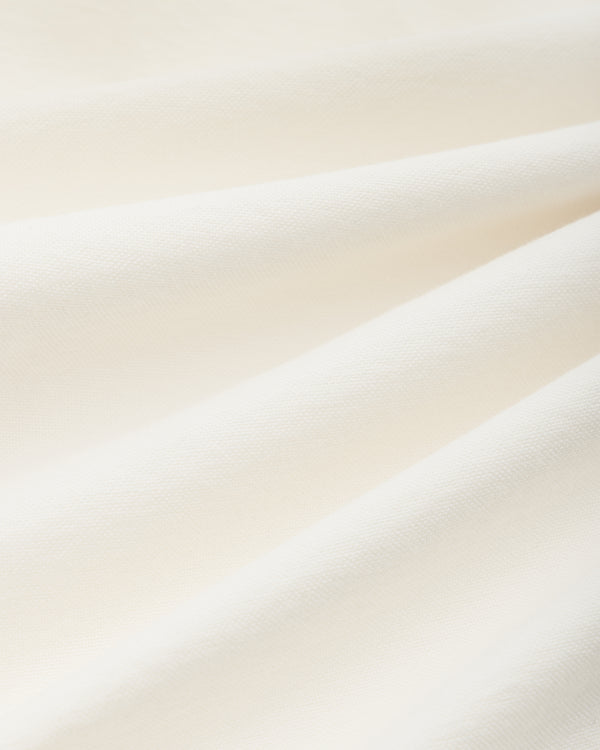 Off-white cotton fabric of the ALD / Olympiacos F.C. Logo Oxford Shirt with soft, diagonal folds.