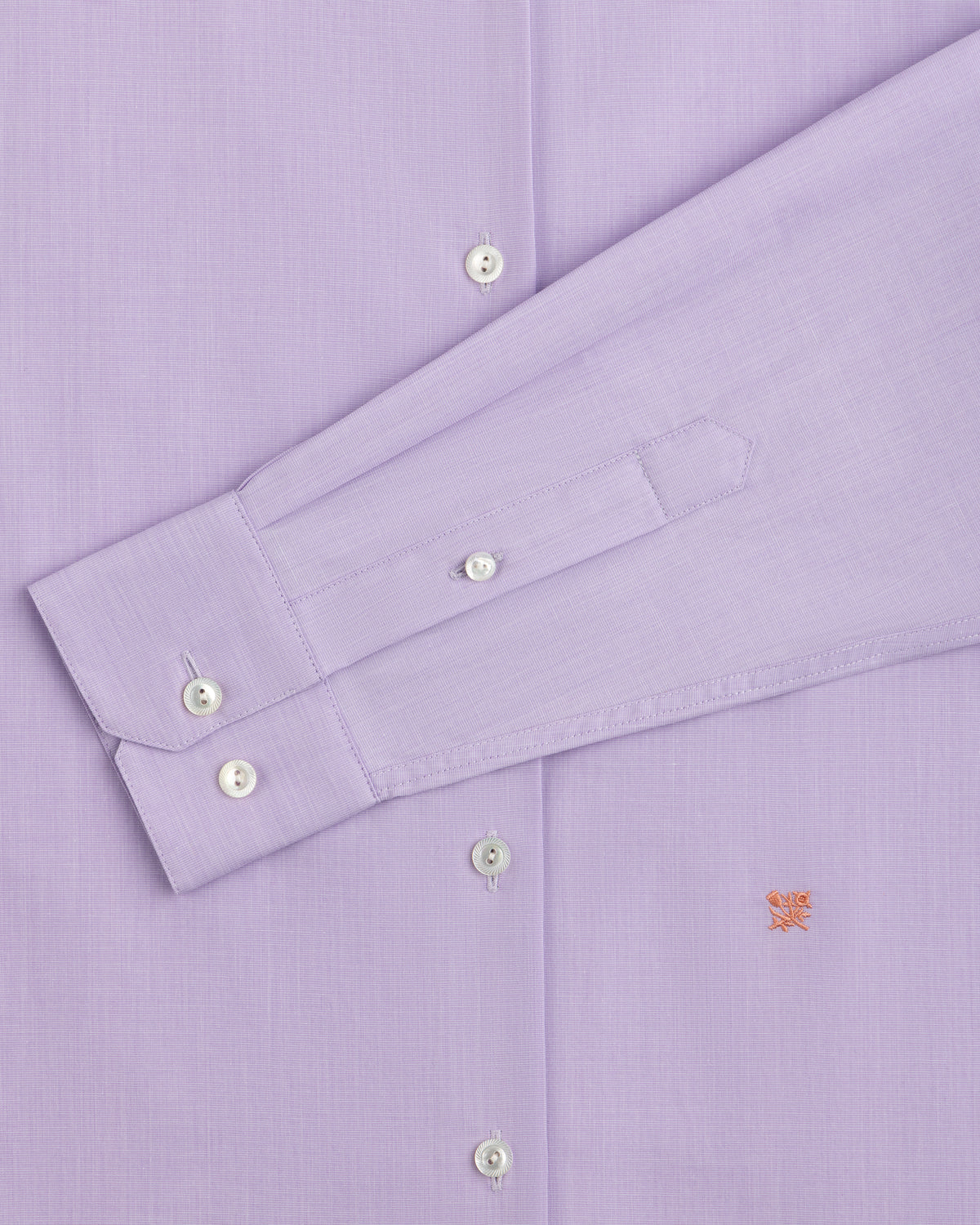 Close-up of a light purple Button Down Poplin Shirt with a buttoned cuff and a small embroidered logo on the chest.