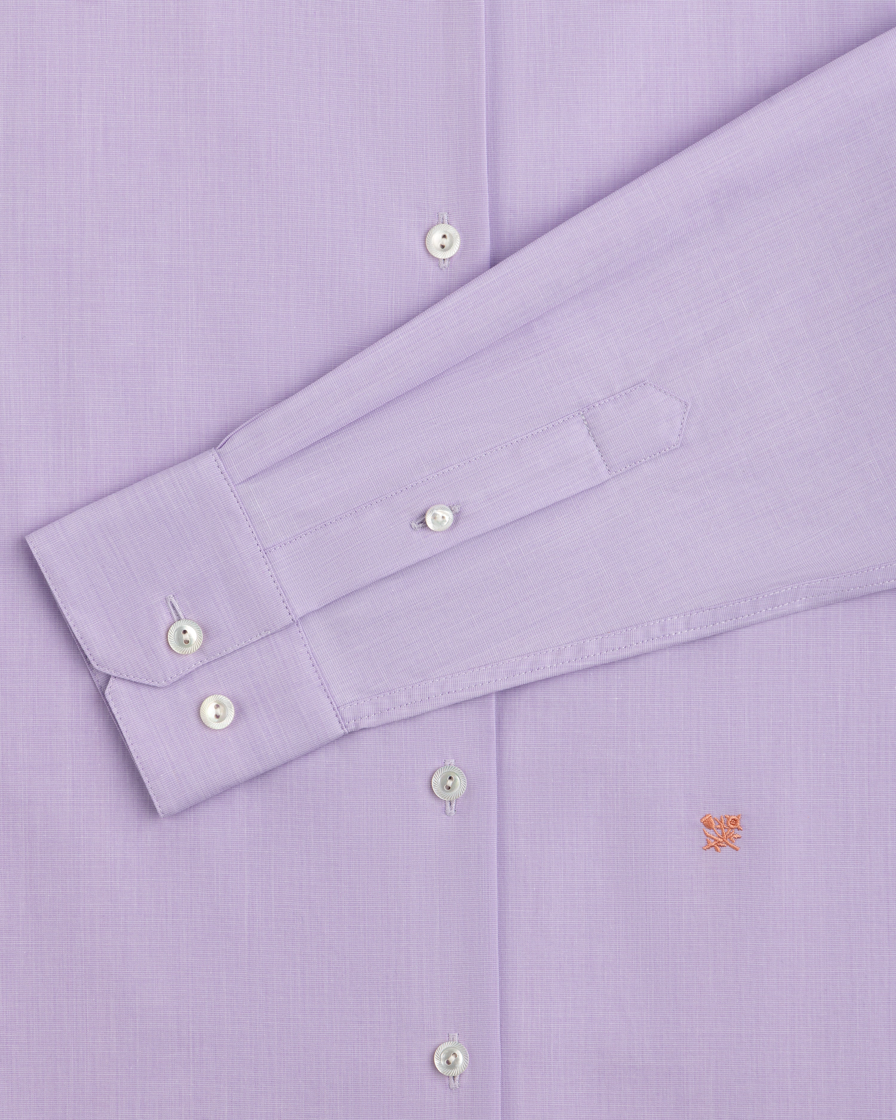 Close-up of a light purple Button Down Poplin Shirt with a buttoned cuff and a small embroidered logo on the chest.