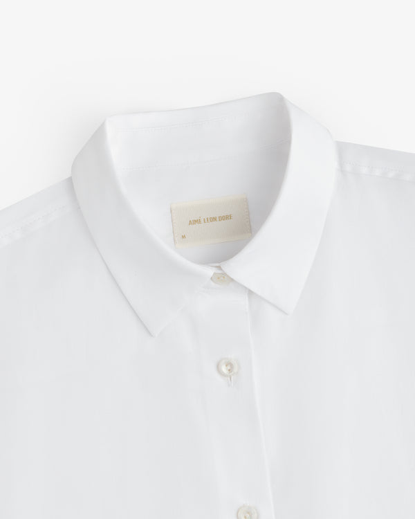 Close-up of a Button Down Poplin Shirt collar in white, featuring a branded neck label.