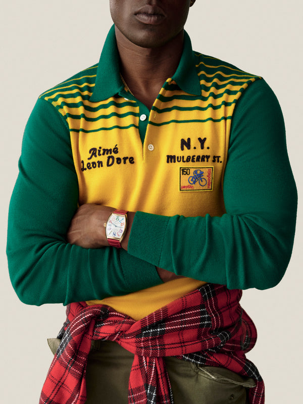Person in Merino Wool Knit Cycling Polo, arms crossed, red plaid shirt tied at waist.