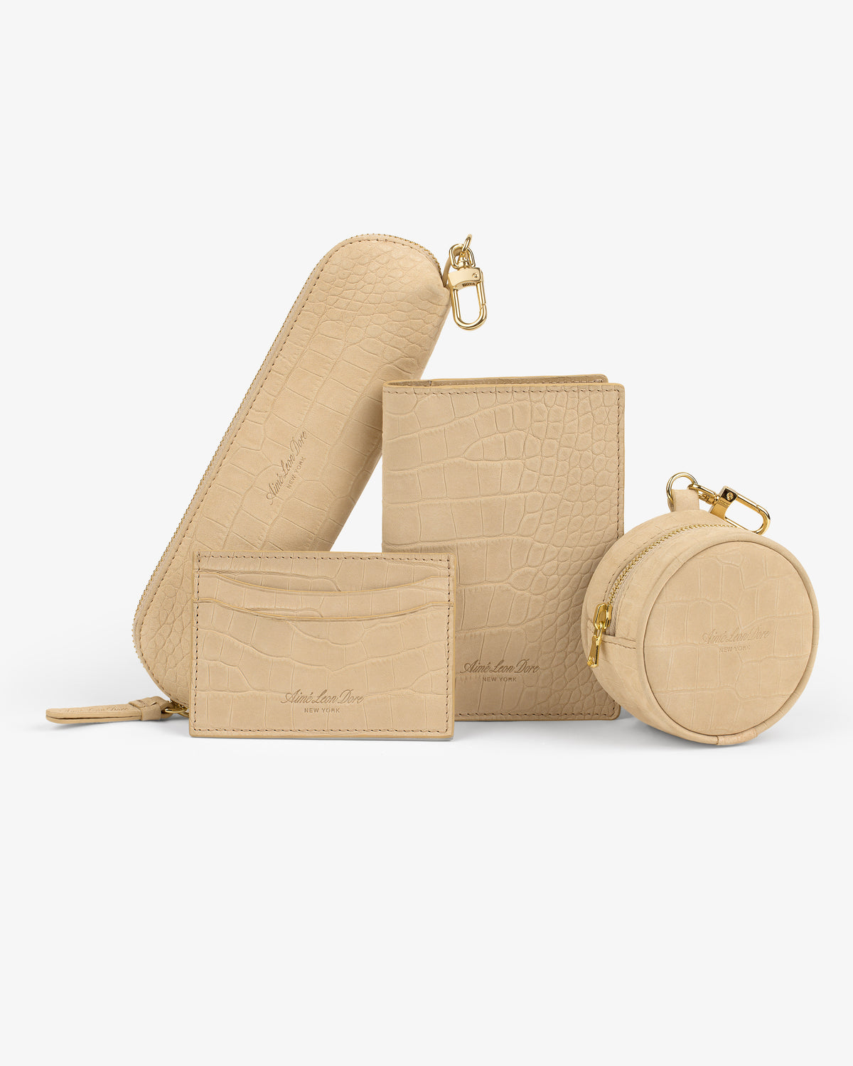 Croc-Embossed Nubuck Passport Holder in beige with a gold zipper, part of four matching leather accessories.