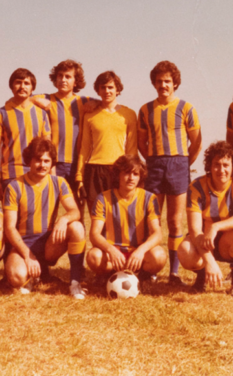 Mens soccer team posing for photo on a field