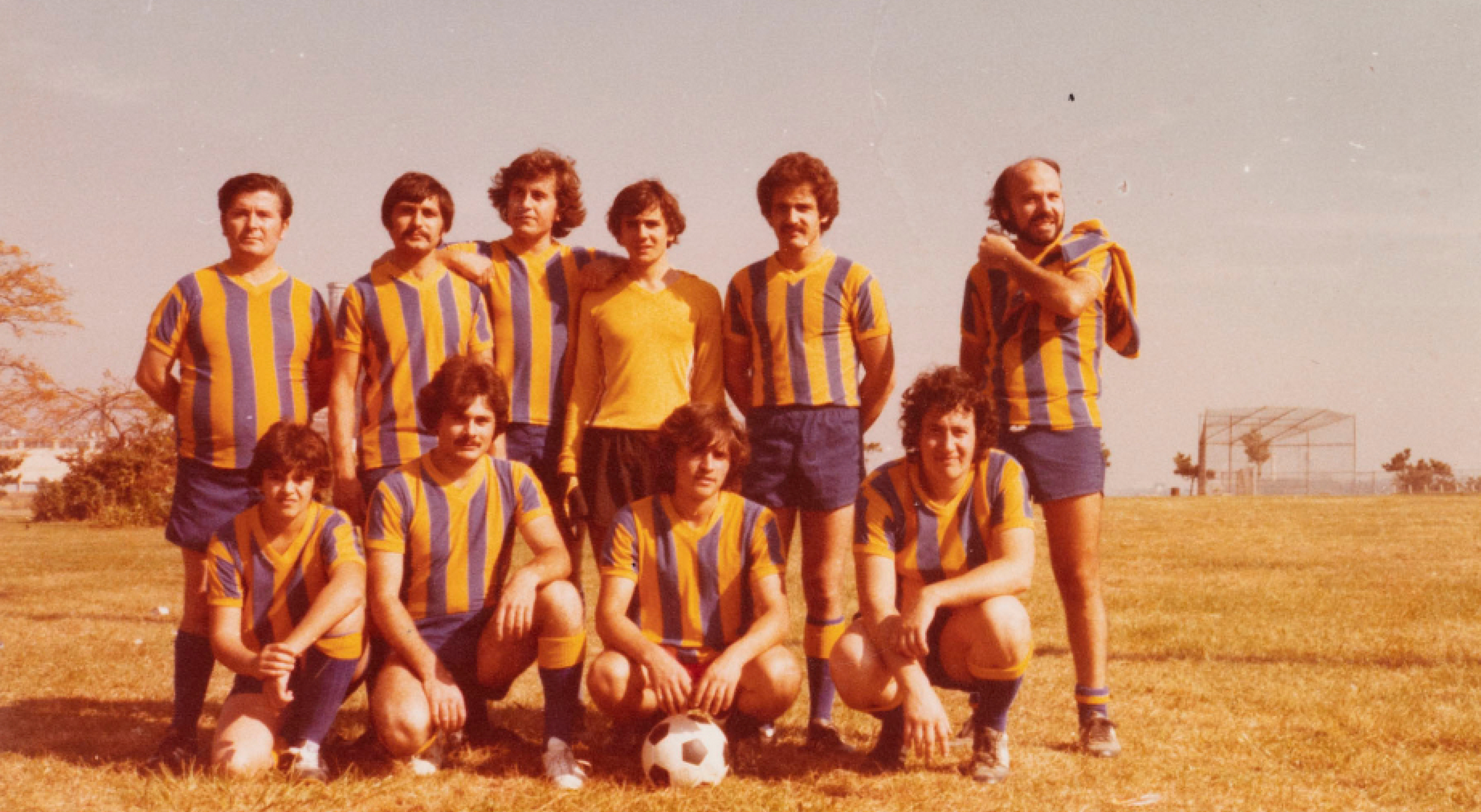 Mens soccer team posing for photo on a field