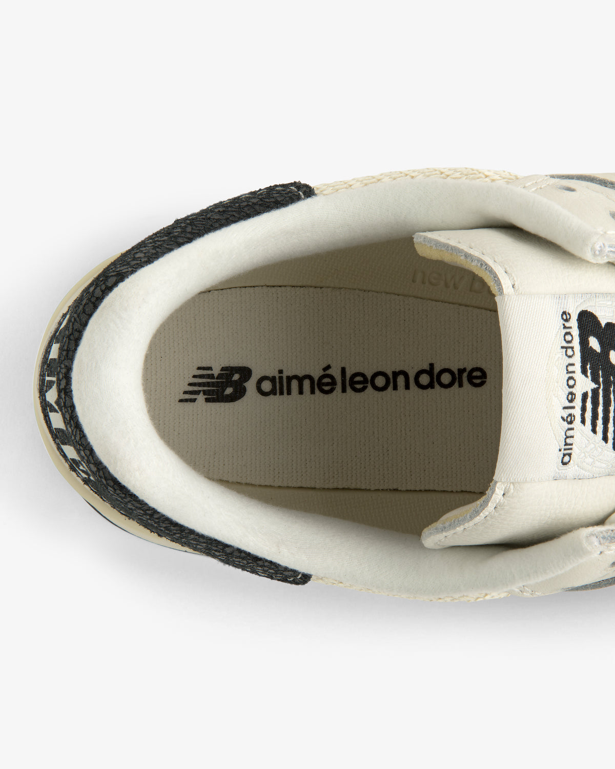 Top view of a white ALD / New Balance 475 with aimé leon dore branding on the insole and tongue.