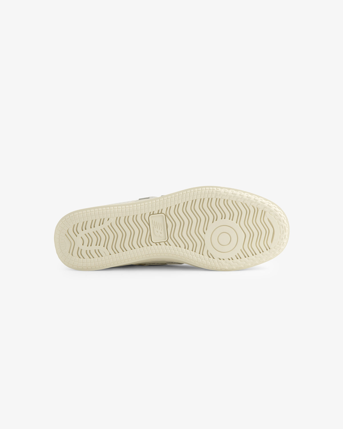 ALD / New Balance T500 Tennis Oxfords in beige, shown from the bottom with a textured sole and circular heel design.