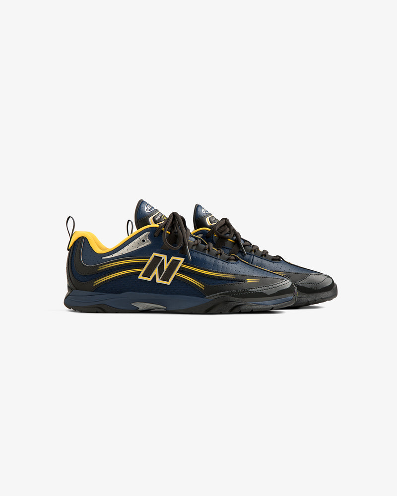 The ALD / New Balance RC56 sneakers in navy and yellow with black soles and big N logos, on a white background.
