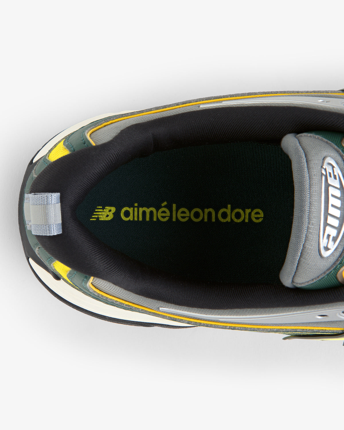 Top view of ALD / New Balance RC56 sneaker shows insole with yellow-green Aimé Leon Dore and New Balance logos.