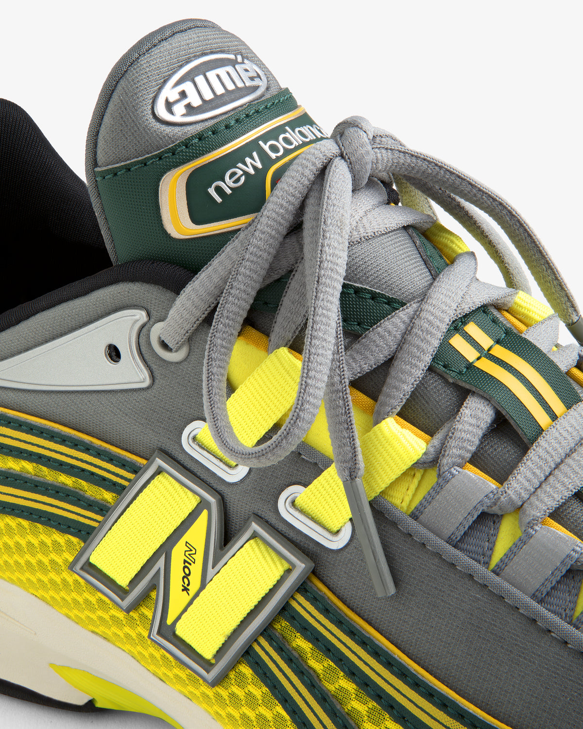 Close-up of a grey and yellow ALD / New Balance RC56 sneaker with prominent laces and detailed branding.