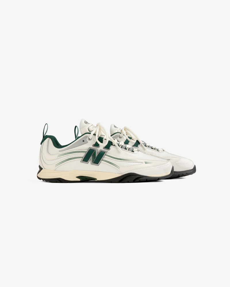 A pair of ALD / New Balance RC56 cream and green sneakers with black soles, side by side on a white background.