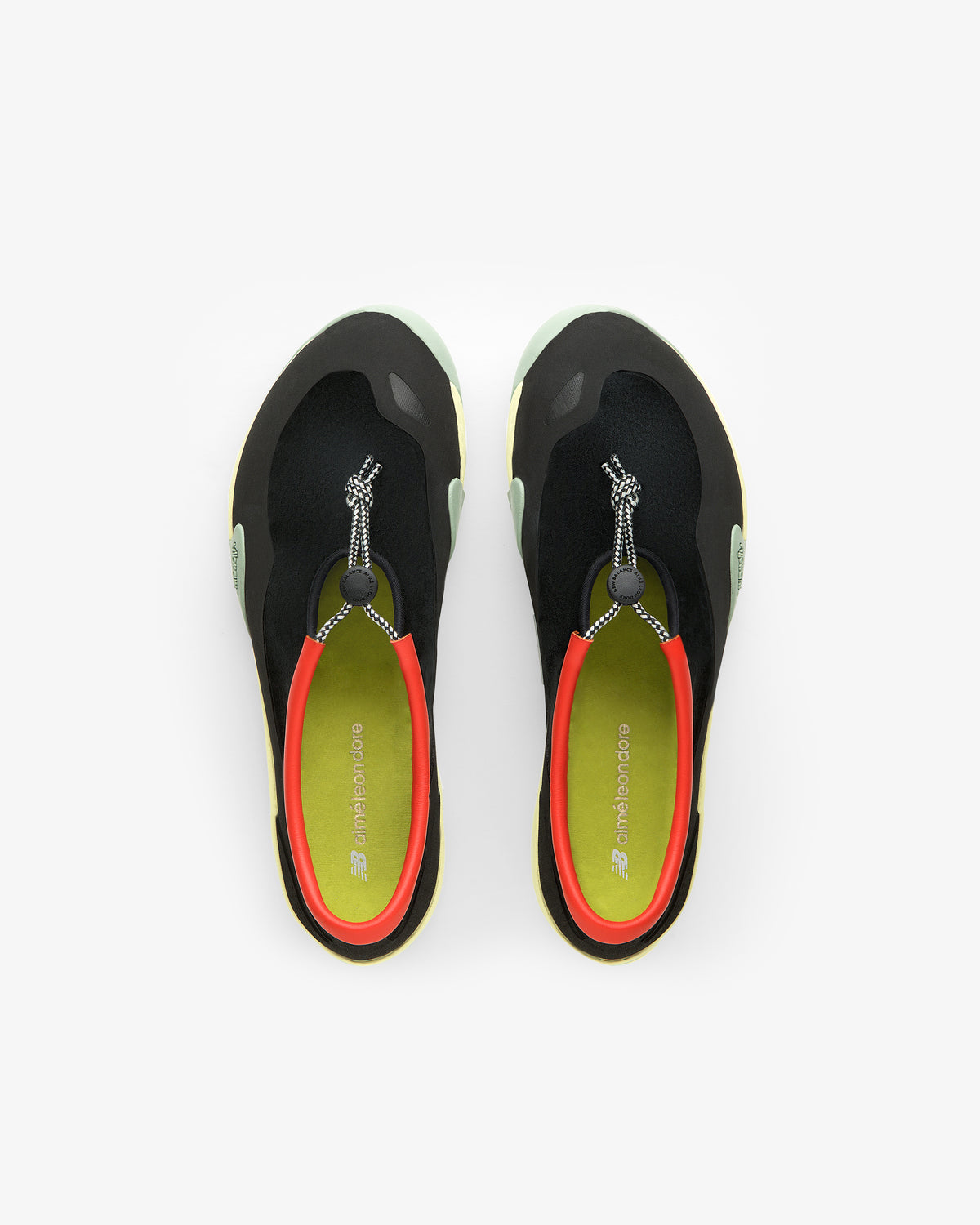 Top view of ALD / New Balance MT10T Sport Shoe in black with red lining, green insoles, and toggle laces.