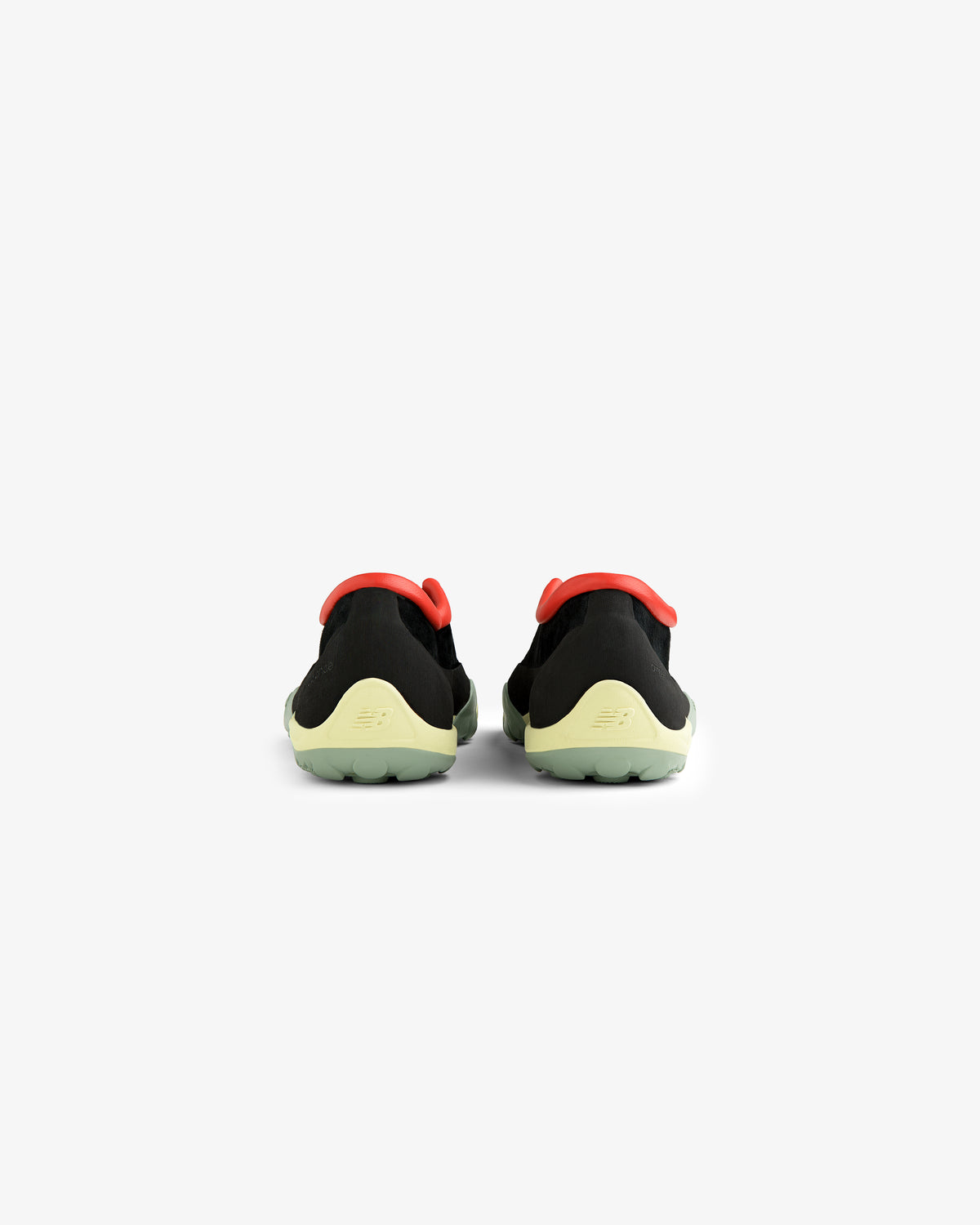 ALD / New Balance MT10T Sport Shoe in black with light green soles and red accents, back view on white background.