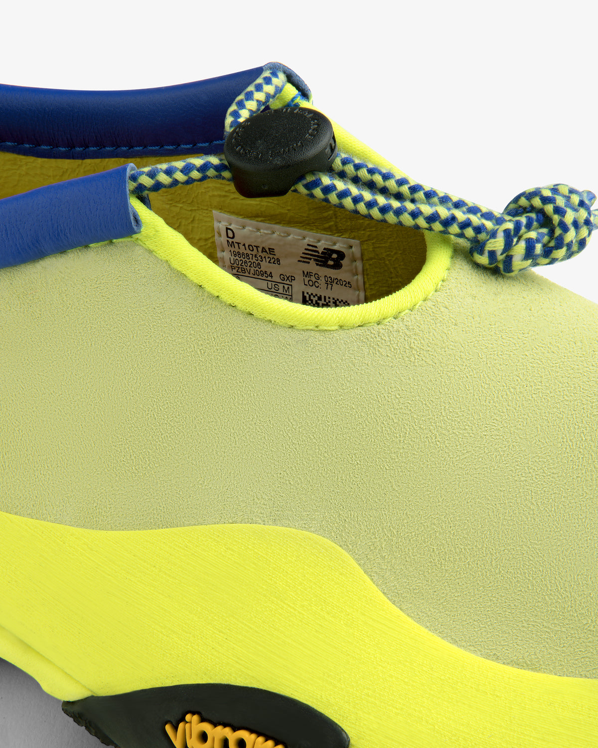 Close-up of the ALD / New Balance MT10T Sport Shoe in yellow and lime with blue-white laces and visible inner label.