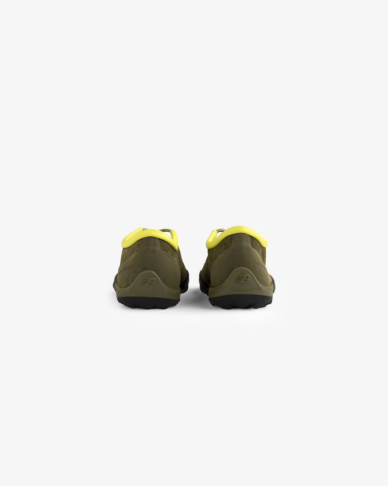 ALD / New Balance MT10T Sport Shoe in olive green and yellow, slip-on style, shown from the back on white background.